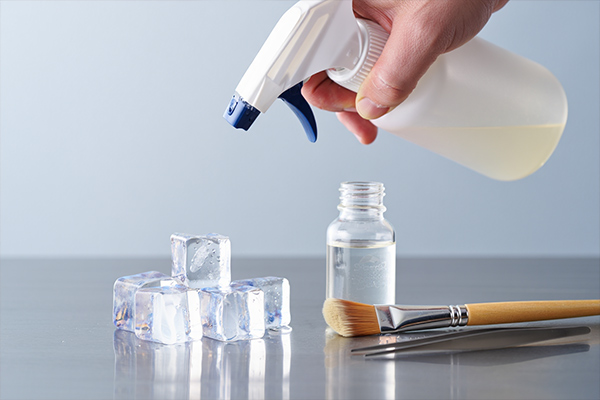 Professional food styling setup showing fake ice cubes, glycerin application, and styling tools in action