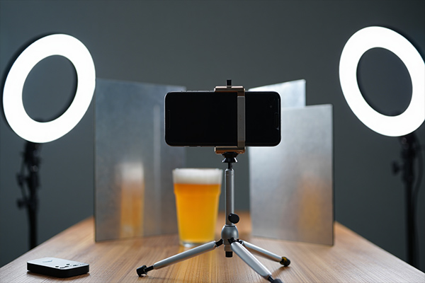 Modern food styling setup with video equipment, sustainable props, and mobile photography showing industry trends