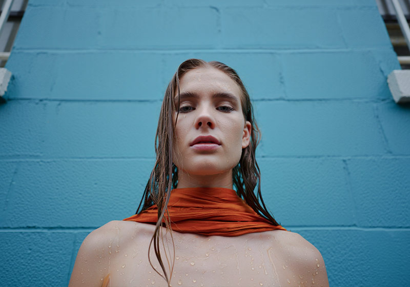 Before - woman with wet hair standing in front of a turquoise-painted wall
