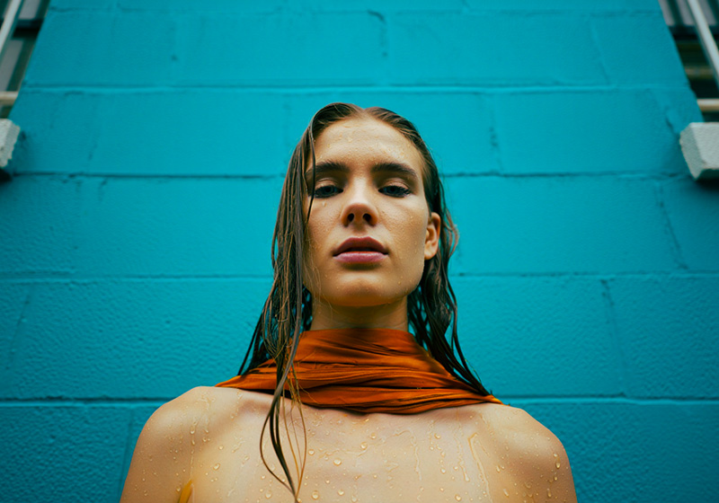 After - woman with wet hair standing in front of a turquoise-painted wall
