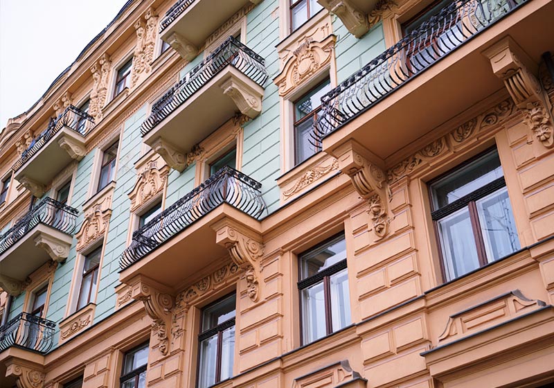 A photo of a city street with pastel-colored buildings lining the sidewak