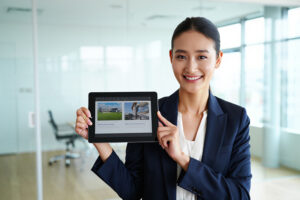 Professional Agents Invest in Premium Presets - Smiling real estate agent holding a tablet displaying polished property photos