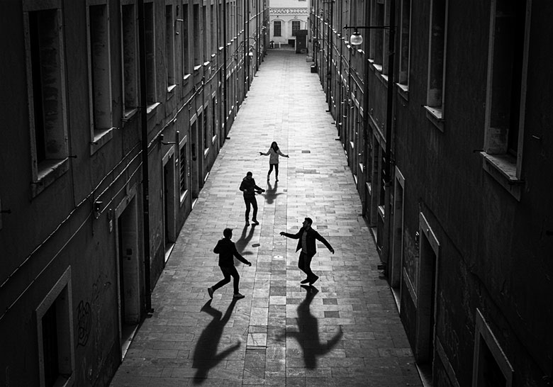 with preset - four people playing in a courtyard