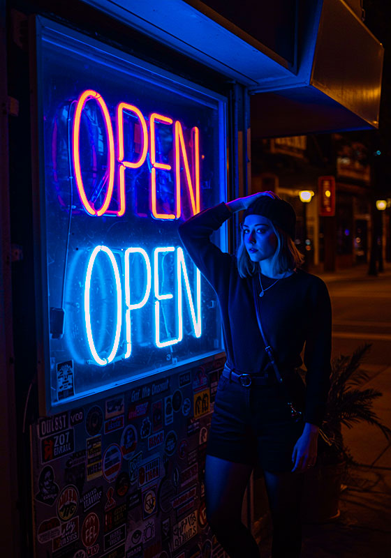 with preset - a woman standing near a OPEN neon sign