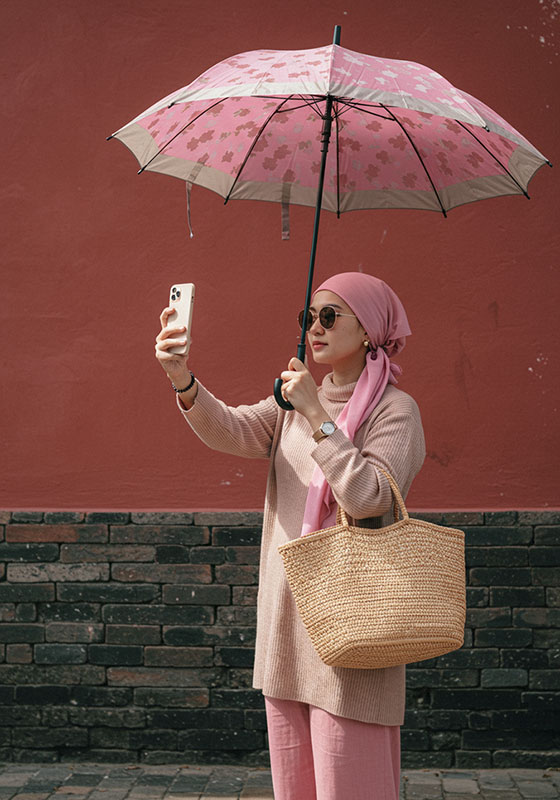 before - young woman holding umbrella taking selfie