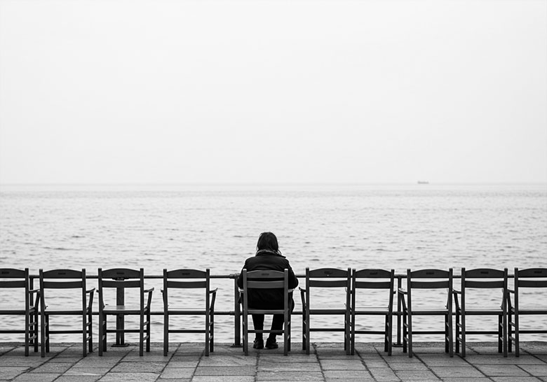 with preset - one lone woman sitting on a chair by the sea