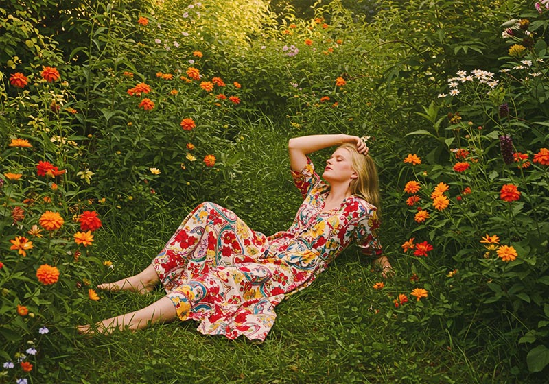 with preset - woman reclining in a lush garden filled with vibrant orange flowers and green foliage