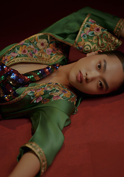 before - a serene model with a calm and introspective facial expression wearing a luxurious green satin dress