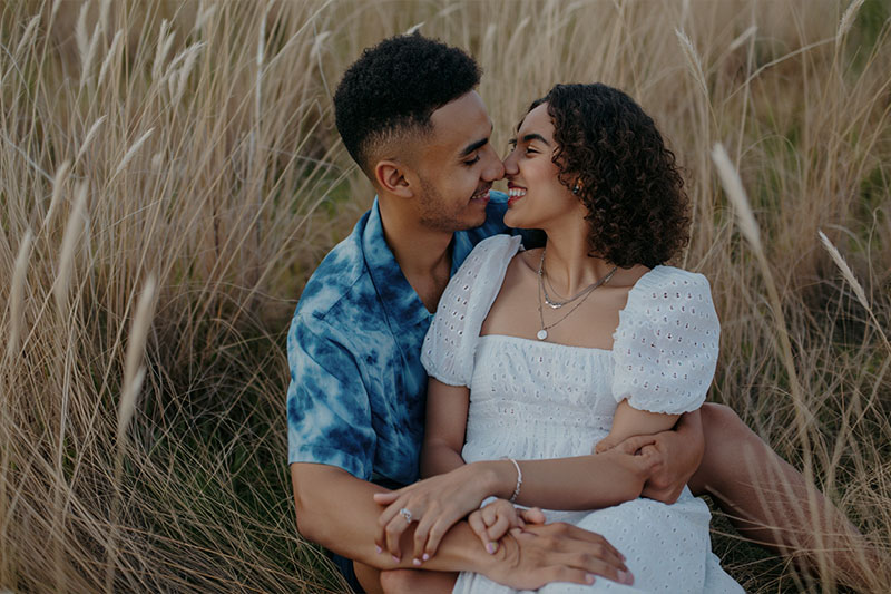 before - romantic scene a couple sitting in a field