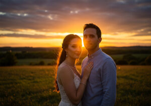 Best Time of the Day for Portrait Photography - A vibrant portrait of a couple standing in an open field during the golden hour at sunset